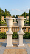 Pair of classical white marble garden urns on matching pedestals